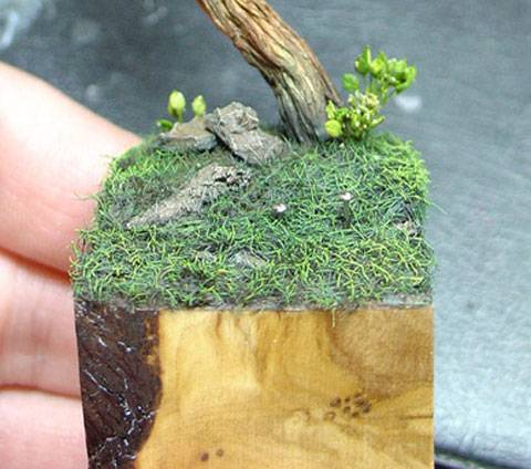 Peana de madera formando una vi&ntilde;eta de un terreno con hierba y arboles