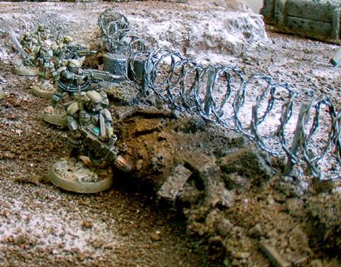 rollo de alambre colocado como defensa entre cascotes en una partida de wargames 