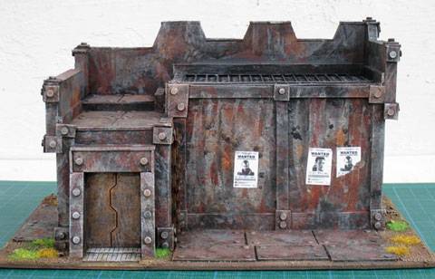 Estupendo edificio imitando la chapa donde podemos subir figuras de wargames de 25 y 28 mm. 