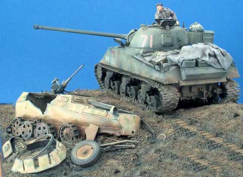 Diorama a escala 1/35 de un Sherman en combate pasando al lado de restos de otros vehiculos.
