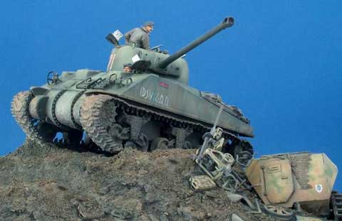 Diorama a escala 1/35 de un Sherman en combate pasando al lado de restos de otros vehiculos.