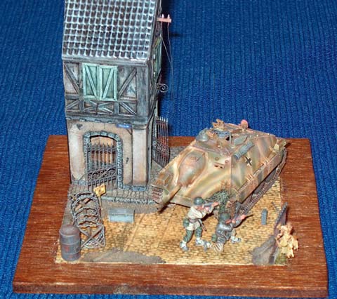 Escena a escala 1/72 de una accion de guerra en la que dos soldados norteamericanos se defienden del enemigo escudandose detras de un carro de combate alem&aacute;n, un Hetzer 38T.  