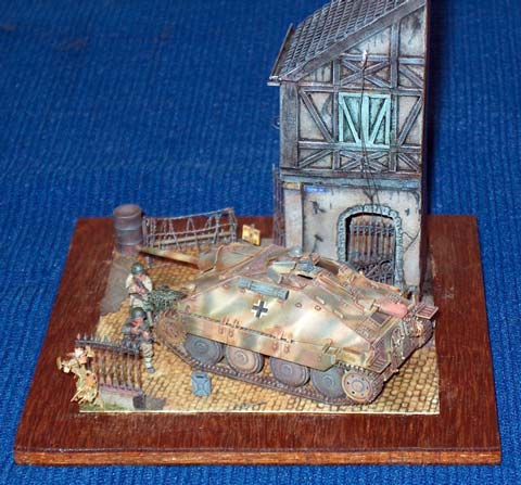 Escena a escala 1/72 de una accion de guerra en la que dos soldados norteamericanos se defienden del enemigo escudandose detras de un carro de combate alem&aacute;n, un Hetzer 38T.  