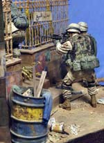 Magn&iacute;fica vi&ntilde;eta/diorama ambientada en Irak de un grupo de soldados peinando una calle casa por casa en busca de terroristas o insurgentes. 