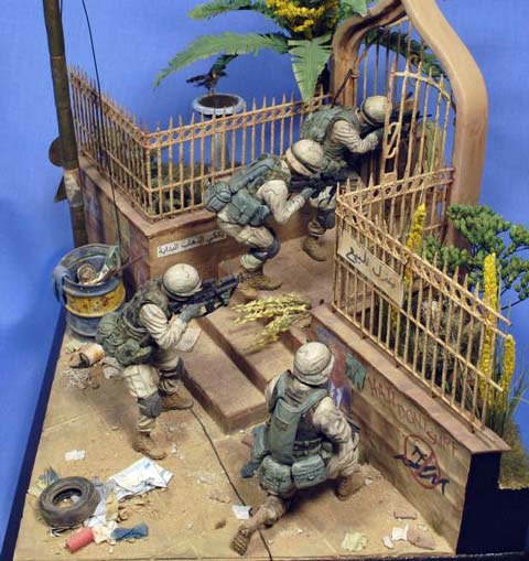 Magn&iacute;fica vi&ntilde;eta/diorama ambientada en Irak de un grupo de soldados peinando una calle casa por casa en busca de terroristas o insurgentes. 