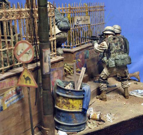 Magn&iacute;fica vi&ntilde;eta/diorama ambientada en Irak de un grupo de soldados peinando una calle casa por casa en busca de terroristas o insurgentes. 