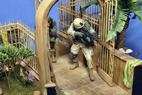 Magn&iacute;fica vi&ntilde;eta/diorama ambientada en Irak de un grupo de soldados peinando una calle casa por casa en busca de terroristas o insurgentes. 